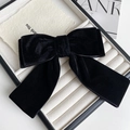 Close-up of a double-layered black velvet bow hair clip with long ribbons on a white tray - Spring Clips / Black