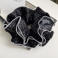 Détail d'un chouchou vintage à pois noirs et blancs avec un bord passepoilé élégant - Noir