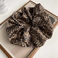 Detailweergave van de satijnen luipaardprint scrunchie met een zachte glans - Luipaard Scrunchie