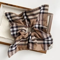 Détail d'un chouchou à carreaux avec bouton décoratif et étiquette sur plateau - Scrunchie À Carreaux Café