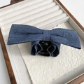 Gros plan d'une pince à cheveux avec nœud en denim bleu dans un plateau en bois luxe - Barrette à cheveux / Denim Bleu Foncé