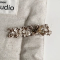 Detail van tweed haarklem met metalen bloem, kristallen inleg en retro nummer 5 ontwerp - Beige Eendenbek Clip
