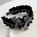 Macro detail of velvet bow headband with sparkling crystals and heart-shaped gemstones - Black