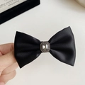 Dettaglio dell'elegante fiocco per capelli in raso nero con un grande cristallo centrale e strass - Fermaglio a Becco d'Anatra con Fiocco / Fermagli per capelli a becco d'anatra