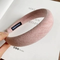 Detail of pink knitted sponge headband with handmade label and woven fabric texture - Pink