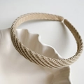 Gros plan du bandeau tricoté beige avec texture détaillée sur assiette blanche - Khaki
