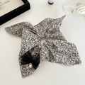 Détail du chouchou floral avec nœud en dentelle noire et élégante perle blanche - Blanc Cassé