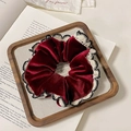 Velvet hair scrunchie in deep red with lace trim on a rustic wooden tray background - Scalloped Style