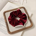 Close-up of wine red velvet scrunchie with white pearl trim on a wooden tray - Mesh Edge Style