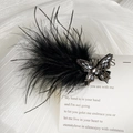 Détail de la pince à cheveux papillon en plumes noires avec des strass étincelants - Style Papillon Droit