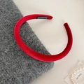 Detail of handmade red velvet padded headband placed on a soft grey knit sweater - Red