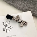 Detailaufnahme einer luxuriösen Haarklammer aus schwarzem Samt mit glitzernder Strassschleife - Schwarzer beflockter Strass-Schleifen-Stil