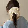 Elegant cream fabric scrunchie with faux pearls worn on a stylish low ponytail - Off White