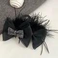 Dettaglio dell'elegante pinza per capelli in piume di struzzo nere con fiocco e strass - Taglia Grande 13cm