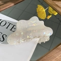 Dettaglio di un grande fermaglio per capelli iridescente con finitura madreperlacea - Bianco Cangiante Sirena