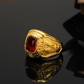 Detail view of gold men's signet ring with red gemstone and eagle relief carvings - US 7 / Gold Red