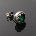 Gros plan d'une boucle d'oreille en pierre verte avec monture couronne argentée et fermoir papillon - Ton Argent Zircone Verte (Unique)