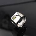 Detalle macro de anillo de sello cuadrado plateado con gema verde sobre espejo - Talla 7 / Color Acero Gema Verde Oliva
