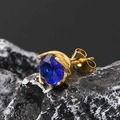 Close-up of gold stud earring with round blue gemstone on textured stone surface - Gold Tone Blue Zircon (Single)
