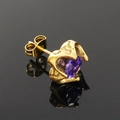 Macro d'une boucle d'oreille rétro en or avec zircon violet et serti griffe sur fond noir - Or Zirconium Violet
