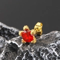 Makroaufnahme eines roten facettierten Edelstein-Ohrsteckers mit vergoldeter Krallenfassung - Gold Roter Zirkonia