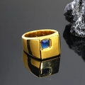 Primer plano de un anillo dorado de hombre con zafiro azul sobre fondo oscuro espejo - Talla 7 / Oro Azul