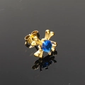 Macro detail van gotische gouden kruis bot oorbel met een ronde diepblauwe steen in het midden - Enkel Stuk / Goud Blauwe Strass (Enkel)