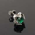 Macro-opname van vintage zilveren hartoorbel met smaragdgroene facetgeslepen steen - Zilver met groene zirkoon