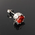 Detailed macro view of a punk gothic stud earring with a large red gemstone and silver base - Steel Red Zircon