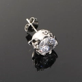 Macro shot of silver punk cross stud earring with a large clear crystal and skull base - Steel Color White Zircon