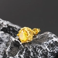 Macro shot of gold-plated stud earring with yellow gemstone on black rock display - Gold Yellow Zirconia