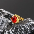 Macro shot of vintage gold stud earring with red zircon on dark natural stone background - Gold Red Zirconia