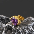 Macro shot of gold-plated stud earring with purple zircon on natural black rock background - Gold Tone Purple Zircon (Single)