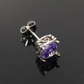 Detalle de un pendiente plateado con piedra morada ovalada y grabados de estilo retro - Circonita Púrpura Acero