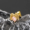 Macro shot of gold punk wing stud earring with a pink zircon stone on volcanic rock - Single Piece / Gold Pink Zirconia