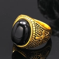 Macro shot of vintage gold-plated ring with large oval black onyx stone and engraved side - Gold Synthetic Black Turquoise