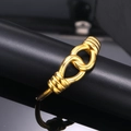 Macro shot of interlocking golden knot bracelet with textured screw detailing - Gold