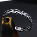 Macro shot of vintage twisted braid design on a titanium steel bangle for men - Antique Silver