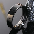 Macro shot of polished black smart ring featuring internal health sensor contacts - US 7 / 7mm / Black