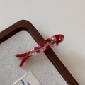 Détail de la pince à cheveux poisson en acétate marbré rouge avec lettrage doré - Rouge