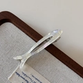 Detail of fish-shaped acetate hair clip with pearlescent finish and engraved tail detail - Mermaid White