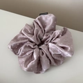 Detail of pink satin polka dot scrunchie with smooth texture and Fashion woven label - Pink