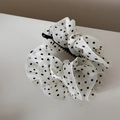Detail van de elegante witte organza stof met stippen op een zwarte grote haarklem - Wit