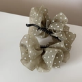 Detail van elegante polkadot chiffon bananenklem met gelaagde stof en fijne textuur - Groen