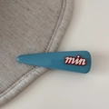 Detailweergave van een blauwe driehoekige haarspeld met rood-witte min letters decoratie - Hoogverzadigd Blauw-Lange Driehoek