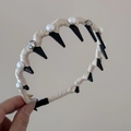 Detalle de la diadema con perlas blancas y tachuelas triangulares negras elegantes - Aro de Dientes Largos Ondulados / Perla Strass Blanco