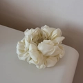 Close-up of a cream white pleated scrunchie with delicate chiffon fabric and refined stitching - Off-white