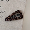 Dettaglio di un fermaglio per capelli triangolare leopardato con trama in tessuto beige - Leopardo Marrone Triangolo
