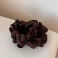 Gros plan d'un chouchou plissé marron foncé avec une texture élégante en mousseline - Marron