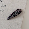 Dettaglio del fermaglio per capelli BB in tessuto leopardato su sfondo di tela beige - Leopardo Grigio Rosa Goccia d'Acqua